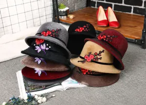Detail of elegant women winter hats featuring colorful flower embroidery on soft faux fur
