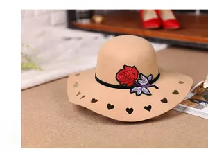 Close-up of red rose embroidery and heart cut-outs on a khaki wool wide-brim fedora hat