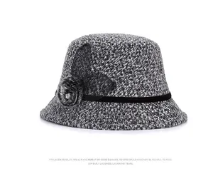 Close-up of winter tweed cloche hat with mesh bow, faux fur pompom, and crystal detail