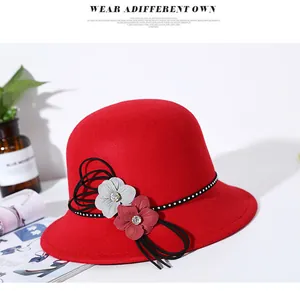 Detail of red wool felt bucket hat featuring rhinestone trim and floral ornaments