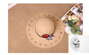 Detail of beige wool fedora featuring hollow heart cutouts and red rose embroidery