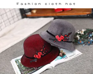 Detailed embroidery of red flowers on stylish burgundy and grey winter bucket hats