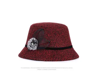 Detail of red and black wool felt bucket hat with mesh floral trim and faux fur pompom