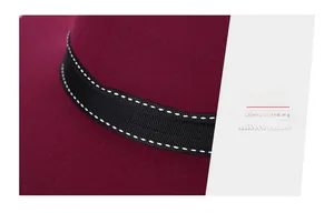 Macro shot of burgundy wool hat featuring exquisite stitching on black ribbed ribbon