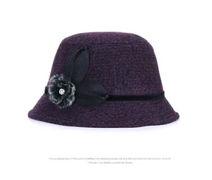 Detail of elegant wool cloche hat with mesh flower, fur pompom and sparkling rhinestone