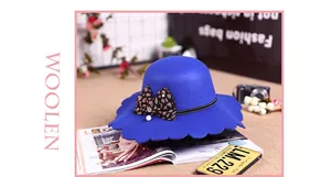 Detail view of royal blue wool fedora with wavy brim and leopard bow with pearl pendant