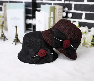 Detail of wool cloche hats with floral bows on a plush rug with vintage decor