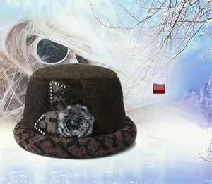 Detail of warm winter hat for senior women in dark brown with faux fur pom pom