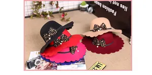 Close-up of scalloped brim wool fedora hat with leopard bow and pearl accents