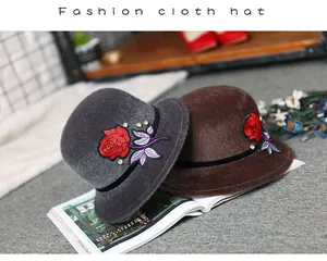 Detail of faux mink cloche hats with red rose embroidery and sparkling rhinestones