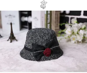 Close-up of elegant cloche hat with rhinestone mesh bow and red fabric rose flower