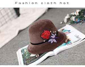 Detail of dark brown faux mink hat with red rose embroidery and rhinestone accents