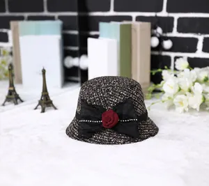 Close-up of mixed tweed bucket hat with black mesh bow and red 3D rose detail
