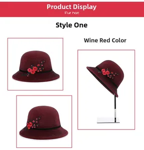 Detail view of wine red faux fur winter hat with elegant floral embroidery and black ribbon