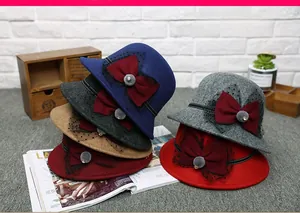 Detail of wool cloche hats with burgundy bows, polka dot mesh and faux fur pom-poms