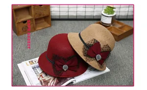 Close-up of wool cloche hats with mesh veil and bow details in burgundy and camel tones