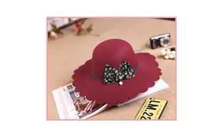 Detail of burgundy wool fedora featuring scalloped edges and leopard print bow decoration