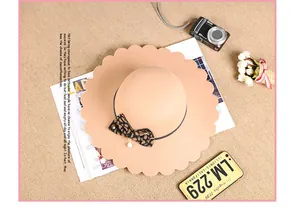 Close-up of wavy petal edge on beige wool fedora with leopard bow and pearl pendant
