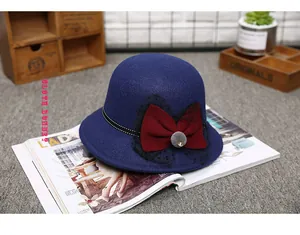 Detailed shot of a vintage wool felt hat featuring a large red bow and polka dot lace trim