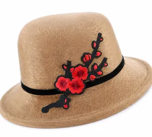 Detailed view of khaki fur hat featuring red plum blossom embroidery and black velvet band