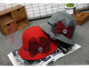 Detail of elegant wool cloche hats with bows and veils in red and grey colors