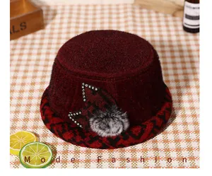 Detail of a burgundy plush winter bucket hat with sequins and a soft faux fur pompom decor