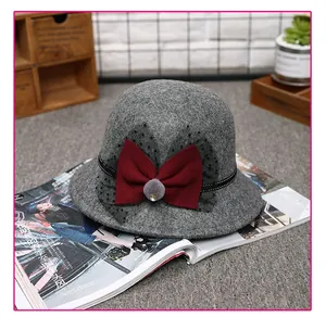 Detail of dark grey wool felt cloche hat featuring a burgundy bow and black polka dot mesh