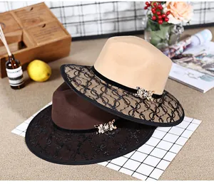 Close-up of wool felt fedora hats with delicate black lace mesh and metal bow details