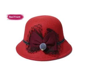Detail of red wool fedora with burgundy bow, black polka dot mesh and center fur ball charm