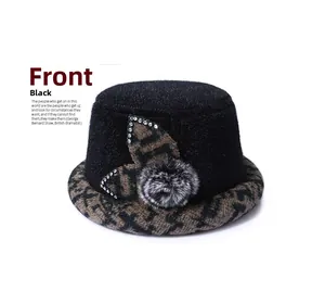 Detail of elegant black winter bucket hat with leopard print brim and rhinestone leaves