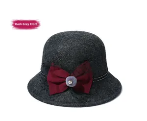 Detail of dark grey wool felt cloche hat featuring red bow and mesh veil decoration