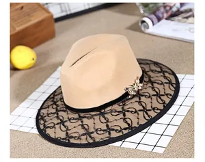 Detail of vintage beige wool fedora featuring black lace brim and gold buckle ornament