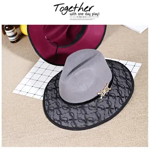 Detail of grey wool fedora hat featuring black lace trim and golden bow buckle accent