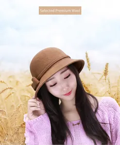 Detail of camel wool felt cloche hat featuring an elegant bow tie in a golden field