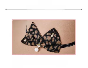 Close-up of beige wool fedora featuring leopard bow, pearl charm and rhinestone details