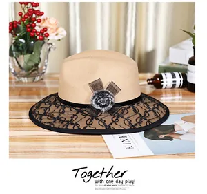 Detail view of camel wool fedora with black lace brim and elegant ribbon decoration