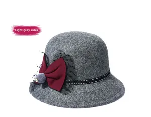 Detail of wool cloche hat in light gray with elegant bow, mesh, and rhinestone accents