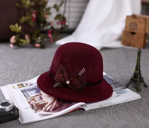 Close-up of wine red wool cloche hat with floral bow and rhinestones