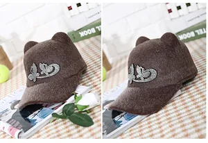 Detail of coffee wool newsboy cap featuring rhinestone butterfly and cute cat ears