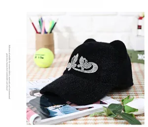 Detail of black faux fur baseball cap with cat ears and rhinestone butterfly accent