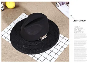 Detail of a black wide-brim fedora with gold metal chain buckle and floral embroidery