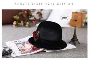Close-up of black wool felt cloche hat with brown bow and rhinestone accents