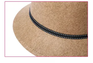 Close-up of brown wool felt hat detailing a black decorative band with white stitching