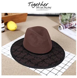 Detail of elegant dark brown wool fedora hat featuring black scroll embroidery and ribbon