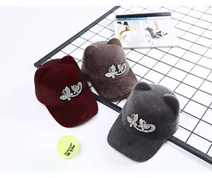 Detailed view of plush equestrian caps with rhinestone bows and cat ears in three colors