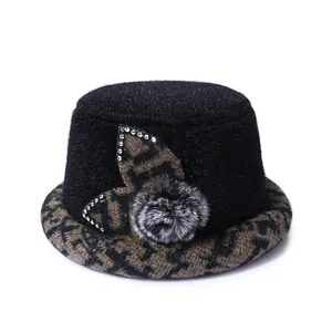 Women's black faux fur bucket hat with houndstooth brim and decorative floral accents