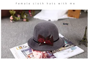 Detail of dark grey cloche hat with rhinestone-studded patterned bow on wool felt