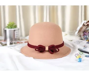 Detail of camel wool cloche hat with elegant burgundy ribbon and bow decoration
