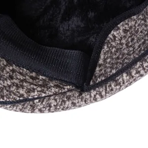 Macro detail of men's winter flat cap featuring thick tweed outer and warm fleece lining