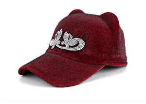 Close-up of a burgundy plush equestrian cap with cute animal ears and rhinestone accents
